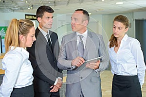 Supervisor with hotel staff holding tablet