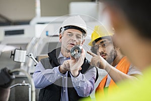 Supervisor and manual worker discussing over metal in industry