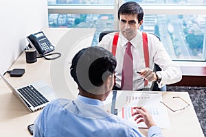 Supervisor talks to subordinate professional in office building photo