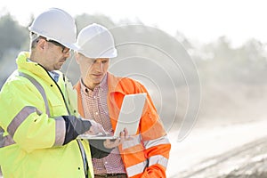 Supervisors using laptop at construction site