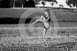 Supple dancer moving in the middle of a field stubble.