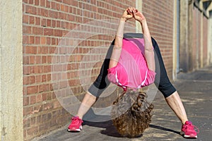 Supple woman doing bending exercises in town