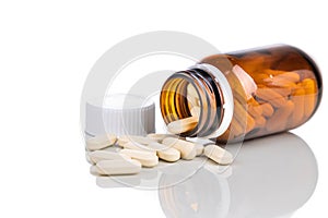 Supplement in caplet format with opaque glass bottle on white background