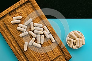 supplement capsules pills on wooden board and on cyan and chalkboard background. dietary supplements top view. immune support