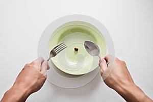 Supplementary food on the dish with fork and spoon on white table