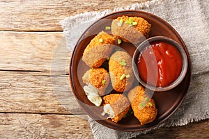 Suppli al Telefono are made with a simple sauce, rice and fresh mozzarella closeup on the plate on the table. Horizontal top view photo