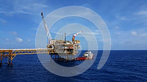Supply boat transfer worker and cargo by personnel basket from platform to supply boat of oil and gas industry.