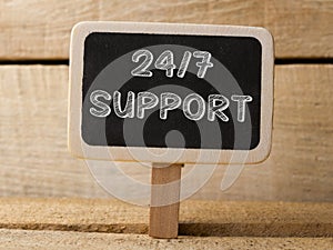 Support 247 text write on Chalkboard at wooden background