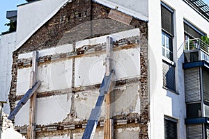 Support of a building wall with wooden struts