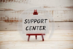 Support Center text on paper card with wooden background