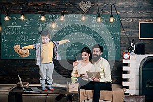 Support concept. Kid holds teddy bear and performing. Boy presenting his knowledge to mom and dad. Parents listening