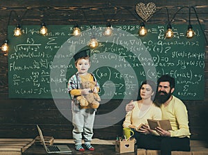 Support concept. Kid holds teddy bear and performing. Boy presenting his knowledge to mom and dad. Smart child in