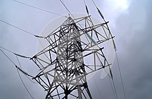 Support of the electric current transmission line against the background of a stormy sky.