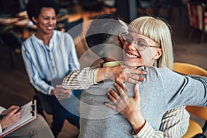 Support group patients hug each other during the therapy session