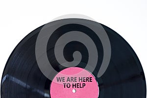 Support and help symbol. Concept words We are here to help on retro black vinyl disc. Beautiful white background, copy space.
