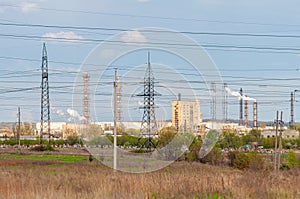 Support of high-voltage power line the blue sky. Flue pipes of a chemical industry plant