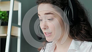 Support hotline worker, girl puts on her headphones and starts talking to the clients.
