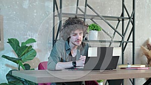Support hotline worker with laptop and microphone at work.