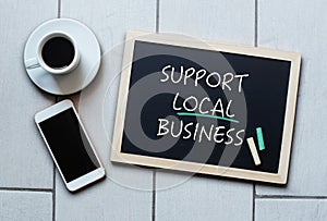 Support Local Business text written on blackboard photo