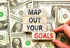Support and map out your goals symbol. Concept words Map out your goals on wooden blocks on beautiful background from dollar bills
