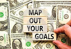 Support and map out your goals symbol. Concept words Map out your goals on wooden blocks on beautiful background from dollar bills