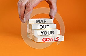 Support and map out your goals symbol. Concept words Map out your goals on wooden blocks on beautiful orange table orange