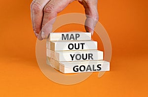 Support and map out your goals symbol. Concept words Map out your goals on wooden blocks on beautiful orange table orange