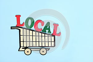 Support and shop local products concept. Wooden shopping cart with word local produce