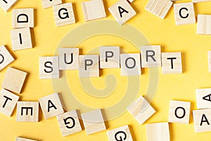 Support sign with blocks on office desk. Wooden ABC