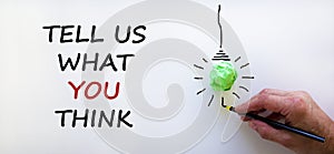 Support symbol. Businessman writing `tell us what you think`,  on beautiful white background. Light bulb icon. Business