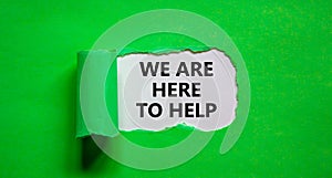 Support symbol. Words `we are here to help` appearing behind torn green paper. Beautiful green background. Business and support