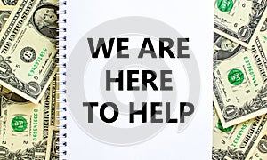 Support symbol. Words `we are here to help` on white note. Beautiful background from dollar bills. Copy space. Business and