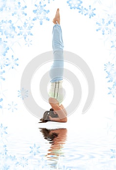 Supported headstand on white sand photo