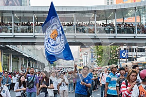 Supporter waves the Leicester City FC flag while waiting for the parade