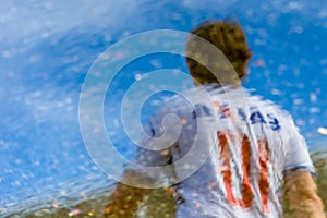 Supporters of the Esporte Clube Bahia football team, seen through the reflection of the water in the vicinity of the Arena Fonte photo