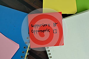 Supporters and Opponents write on sticky notes and supported by additional services write on a sticky notes isolated on Wooden