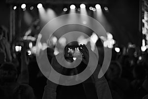 Supporters recording at concert, black and white
