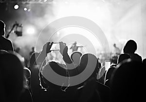 Supporters recording at concert, black and white