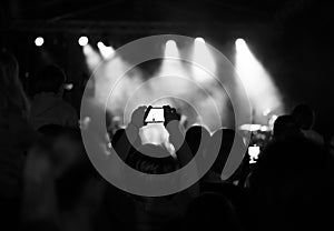 Supporters recording at concert, black and white, noise photo