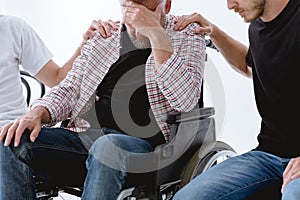 Supporting injured man on wheelchair during psychotherapy for people with ptsd