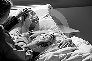 supporting sad, dying woman with tumor in a hospital, black and white photo