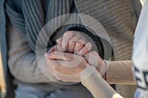 Supporting volunteer shaking hands of homeless aged woman