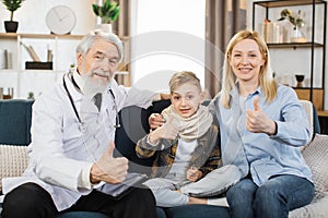 Supportive attentive male doctor visits sick boy patient at home sitting with mom