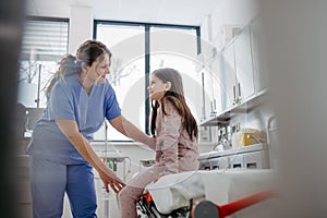 Supportive doctor soothing a worried children patient in emergency room. Concept of emotional support and friendliness