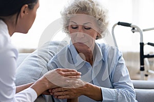 Supportive female caregiver comfort senior woman patient