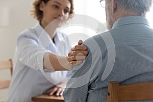 Supportive female doctor comfort elderly patient in hospital