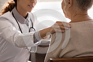 Supportive female doctor comfort old woman client