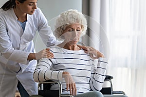 Supportive female nurse take care of disabled elderly woman