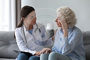 Supportive woman doctor visit senior patient at home