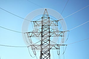 Supports high-voltage power line against a clear blue sky.